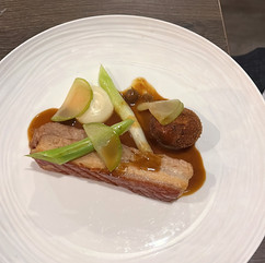 A fine-dining plate of pork belly with sauce, fennel and apple slices