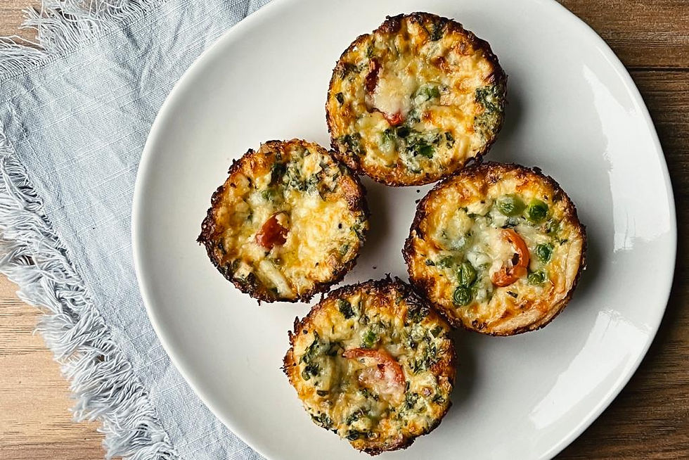 Four little cups, filled with vegetables depict this mini quiche recipe