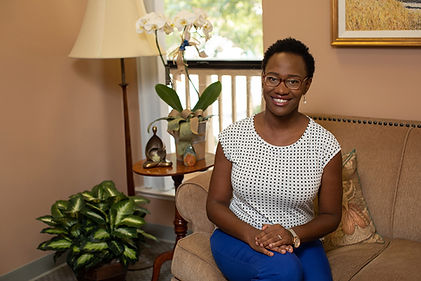 Photo of Dr. Sarah Hill sitting on a sofa in one of the therapy offices