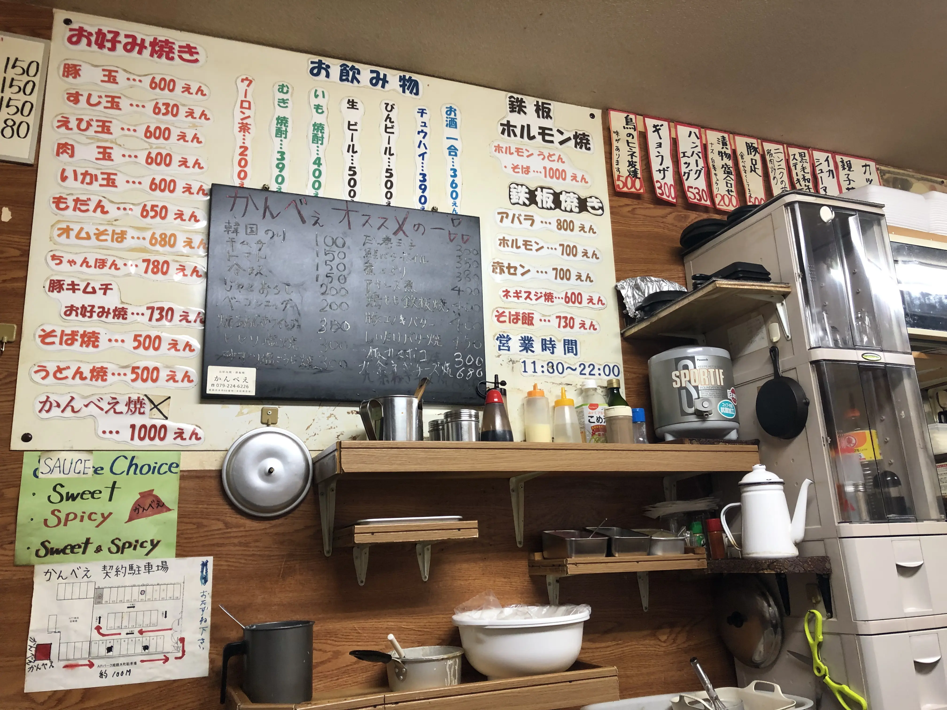 Menu with handwritten prices inside a small local Japanese restaurant, showing cash-only ordering and affordable food options