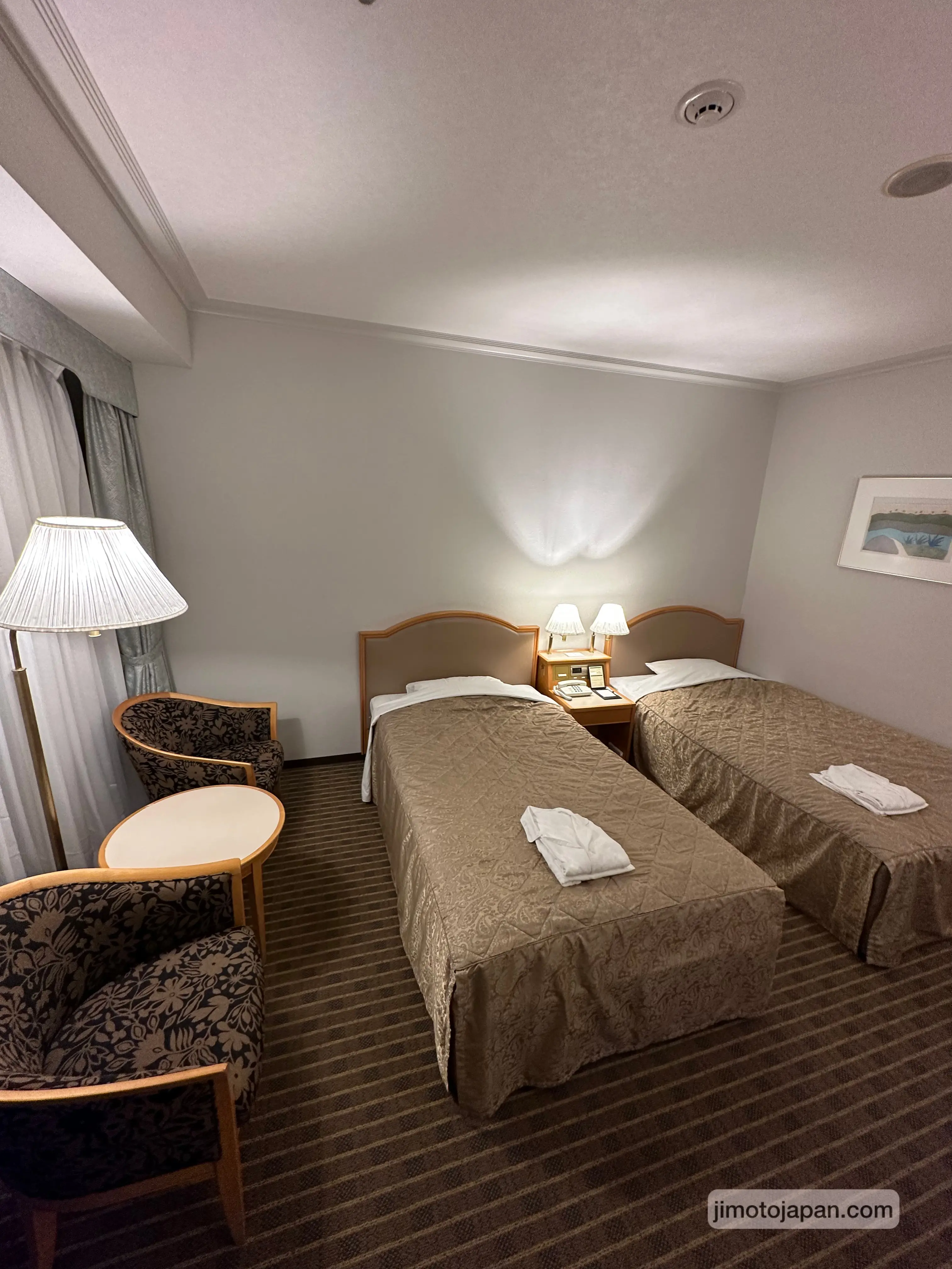 Compact hotel room in Japan with bed and amenities, representing budget-friendly accommodation