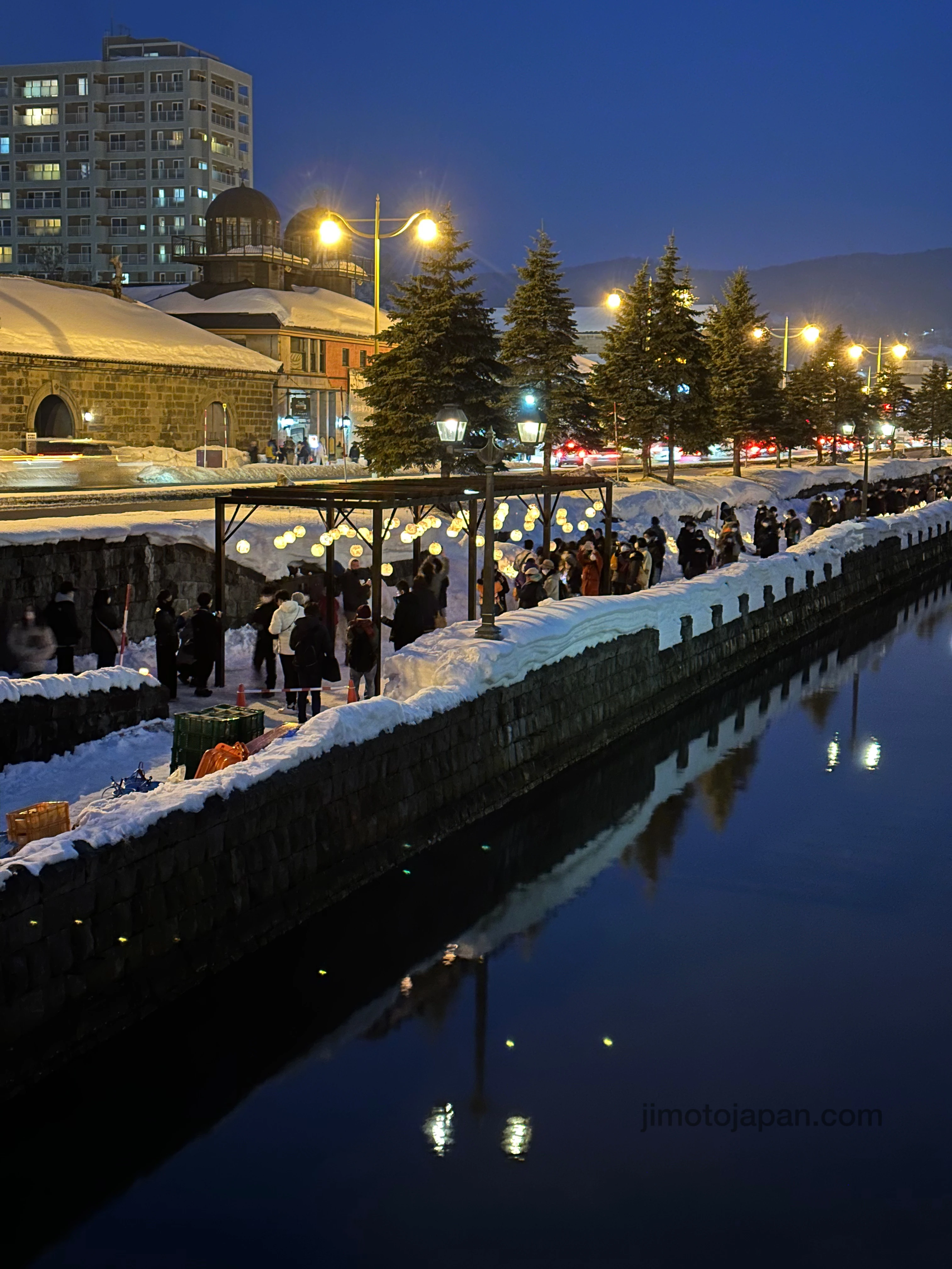 Winter evening in Otaru Canal with snow-covered streets and illuminated lanterns.