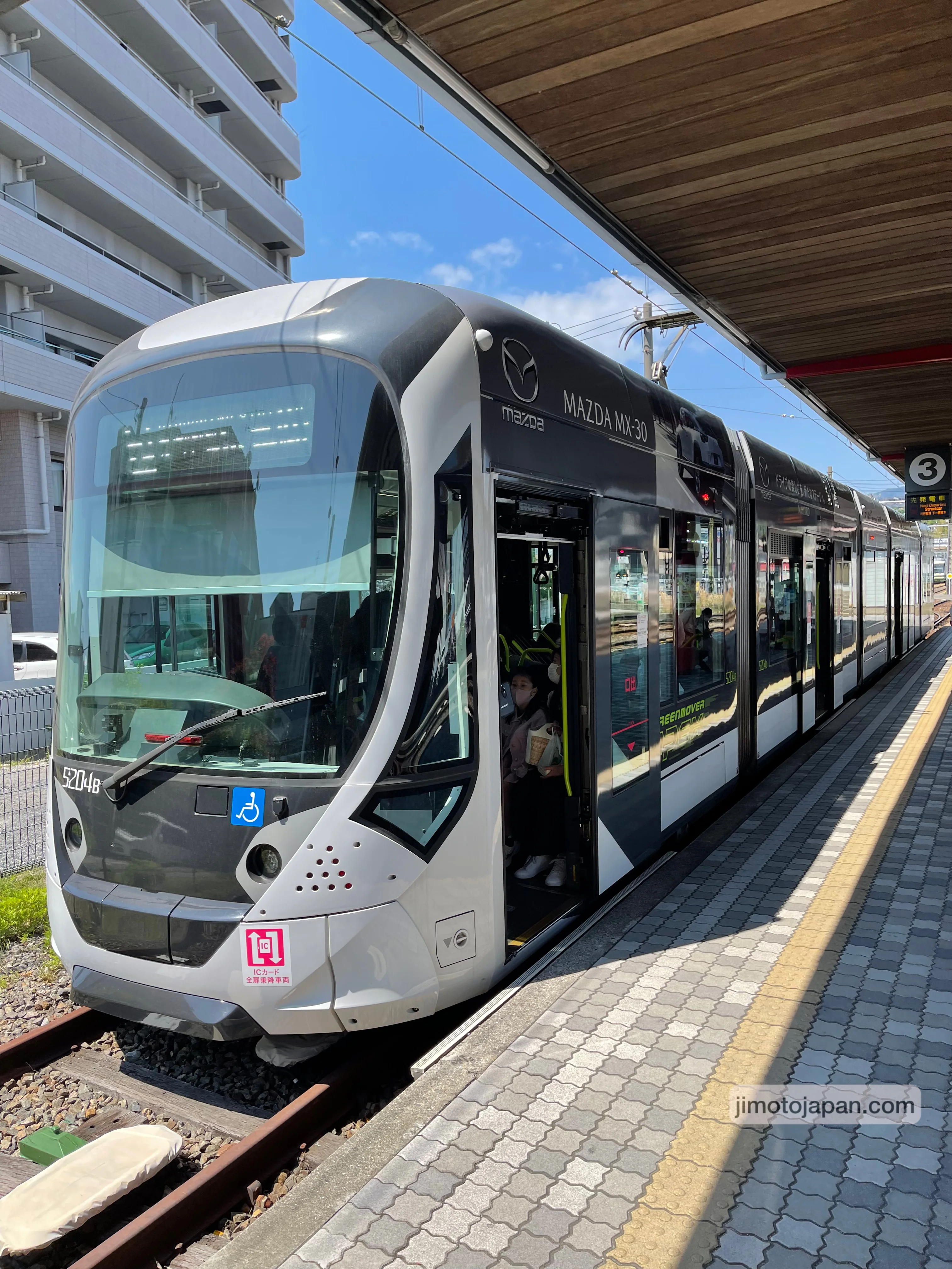 Modern tram in Japan at a station, showing efficient and affordable urban transportation