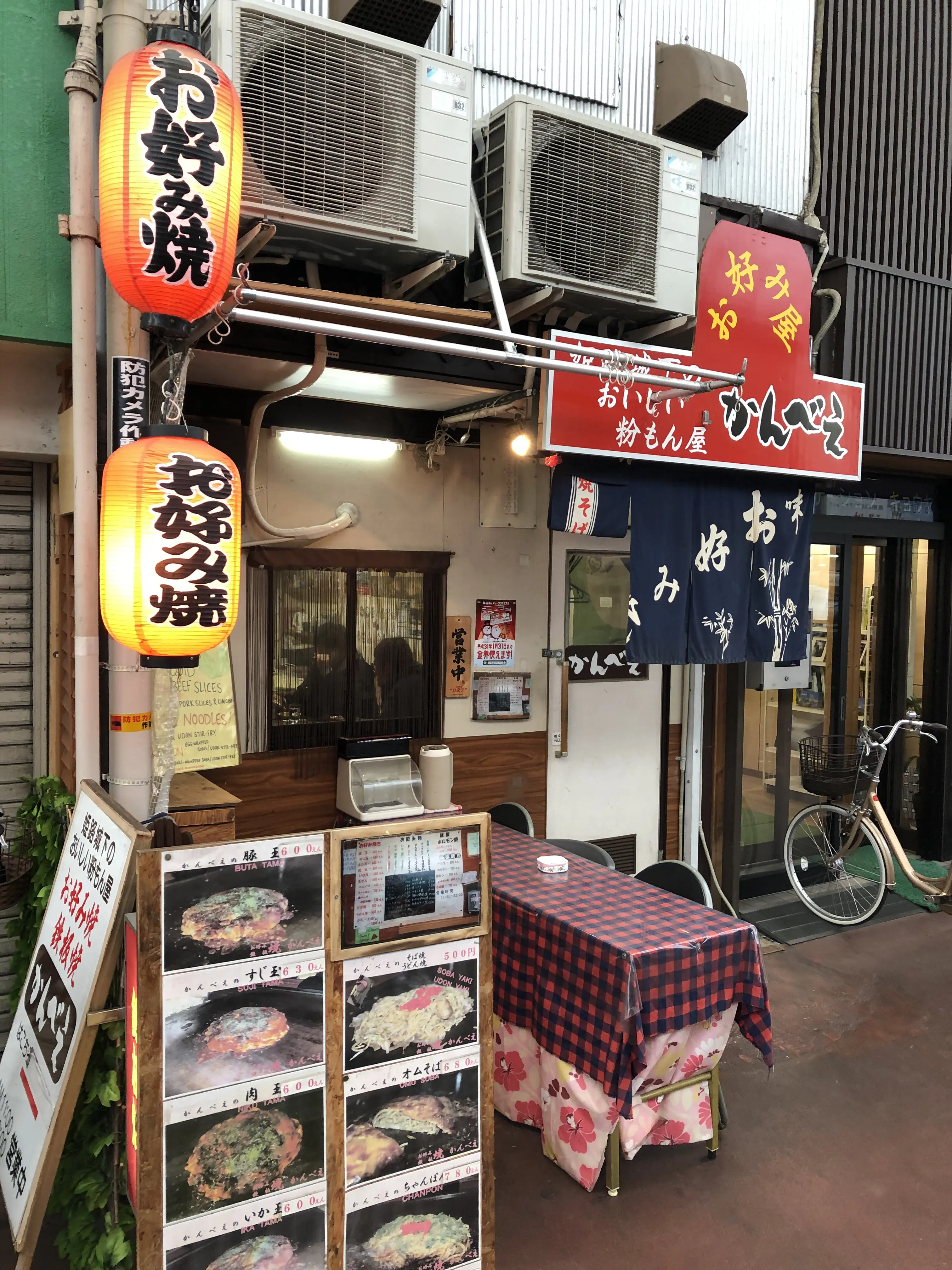Small local Japanese restaurant with menu signs and lanterns, showing a cash-only eatery in a traditional neighborhood
