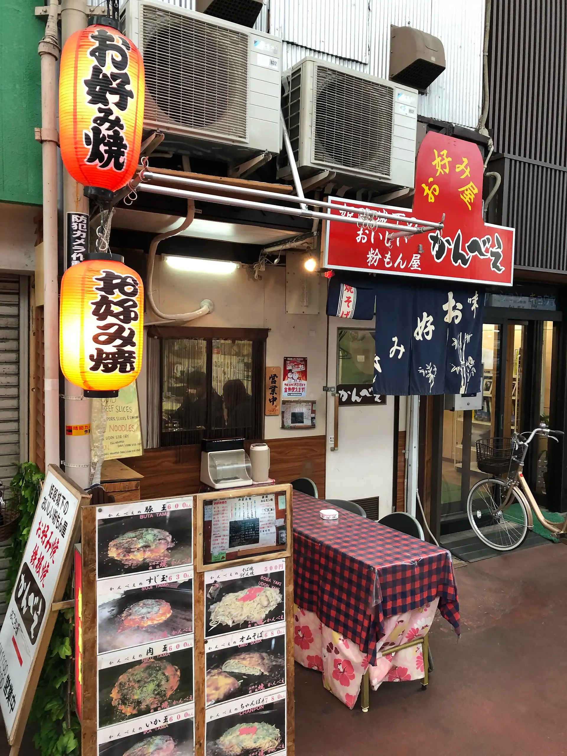 Small local Japanese restaurant with menu signs and lanterns, showing a cash-only eatery in a traditional neighborhood