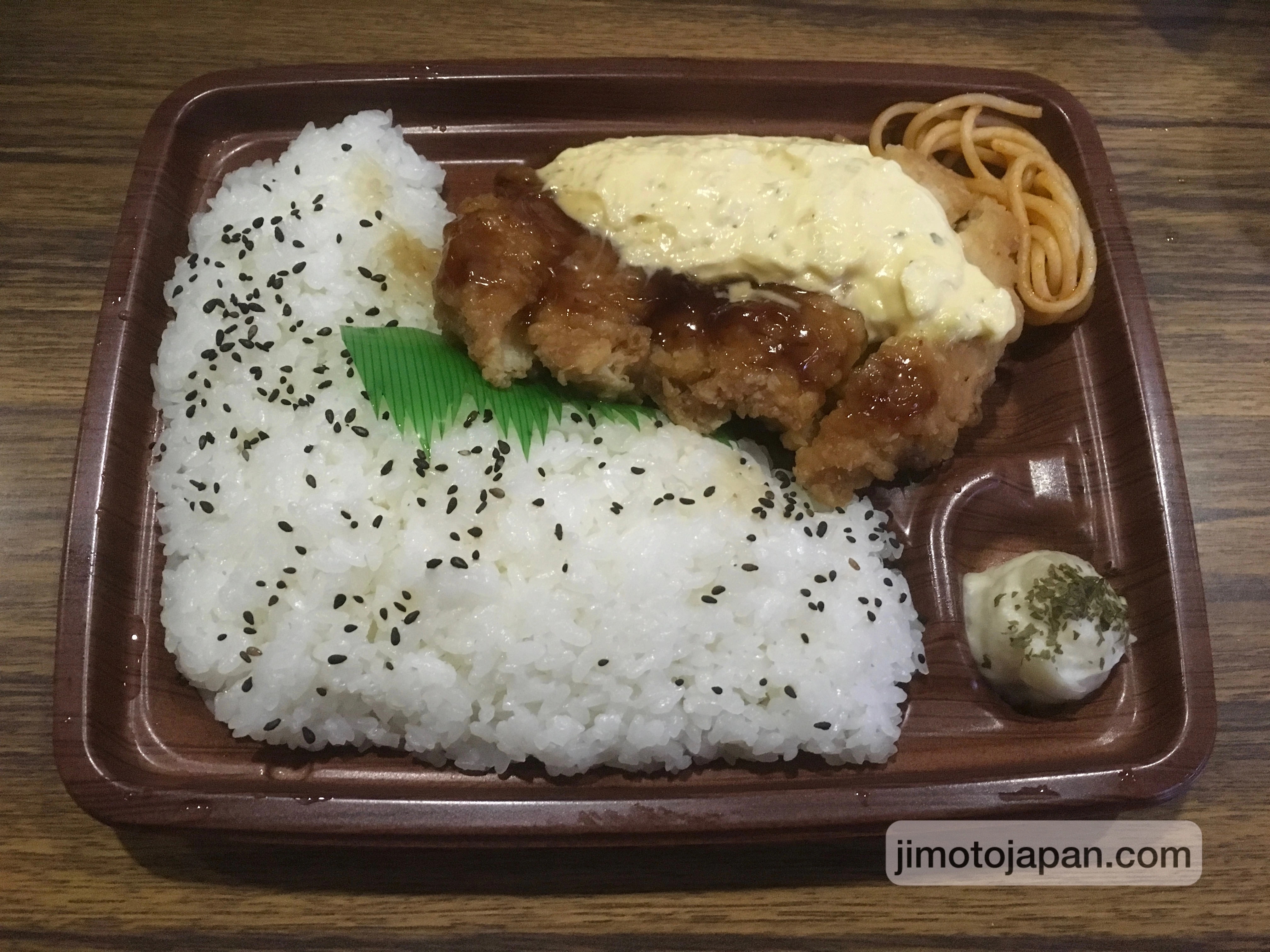 Simple Japanese bento meal with rice and fried chicken, showing affordable everyday food in Japan