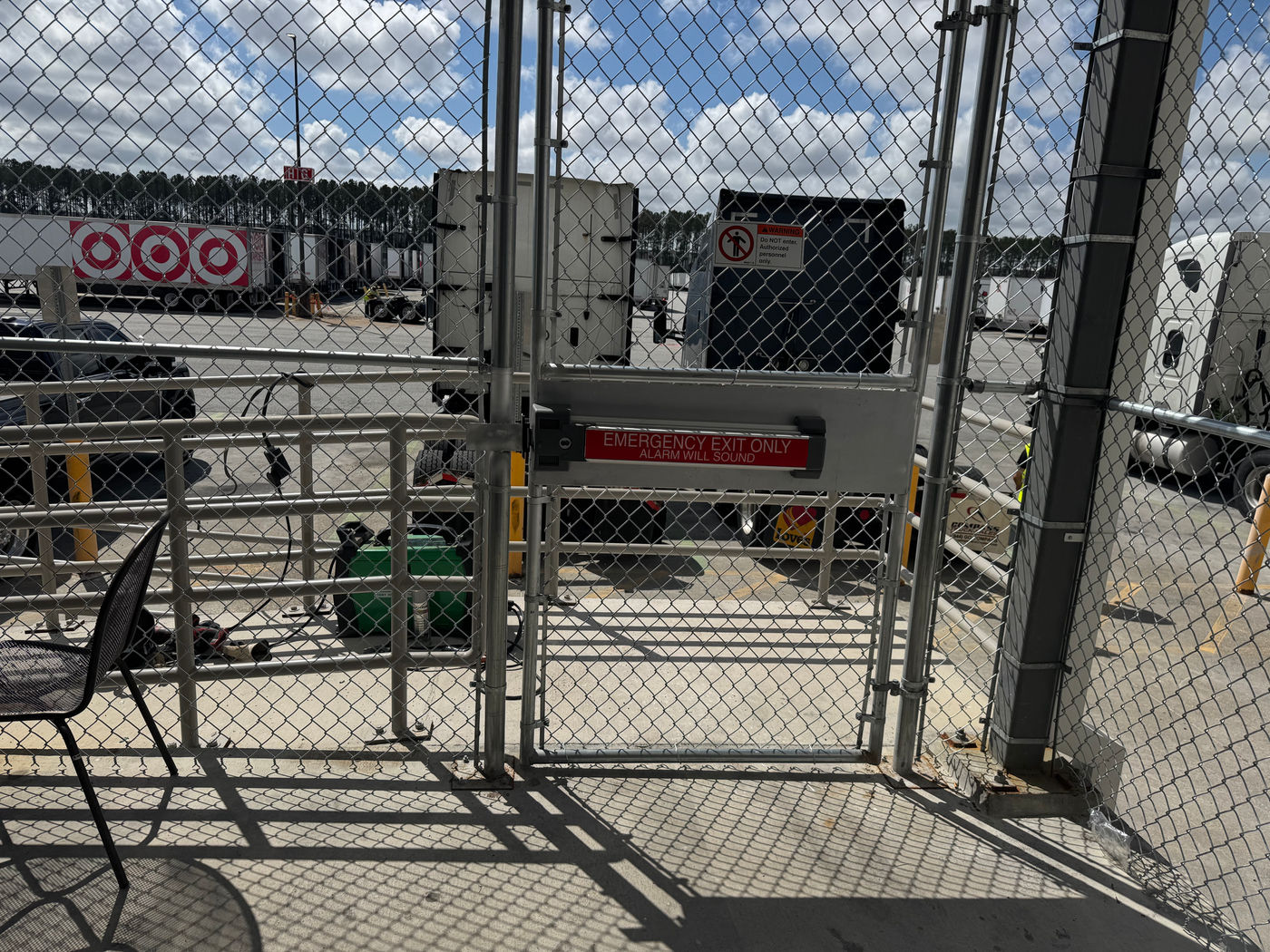 Custom galvanized chain-link emergency exit gate with alarmed panic bar at a distribution center