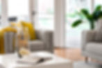 Bright living room with comfy chairs, yellow pillows, and stylish decor