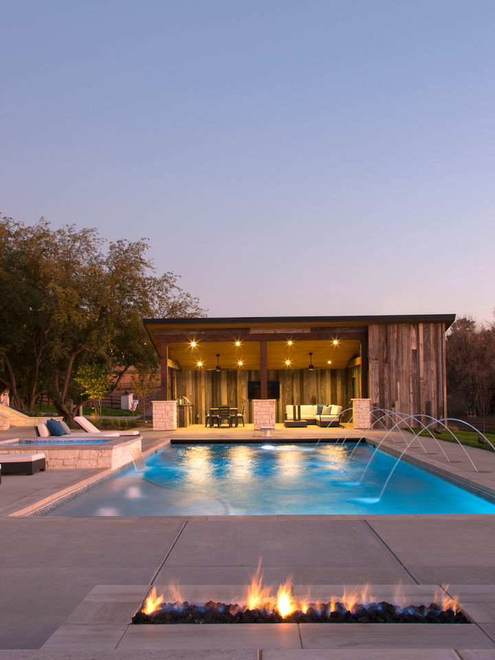 Luxury swimming pool with fire pit, and building; Residential, at dusk KLI New