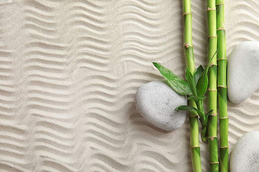 bamboo-branches-with-spa-stones-on-sand-top-view