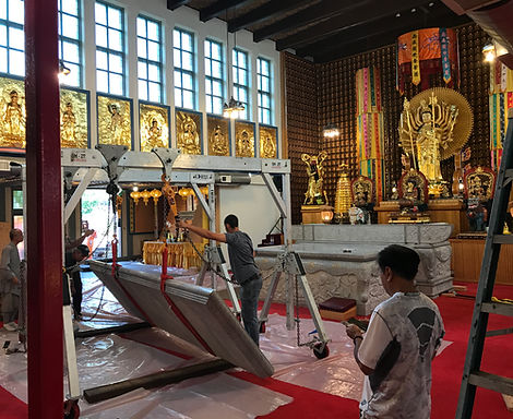 Workers moving large display with rigging machinery
