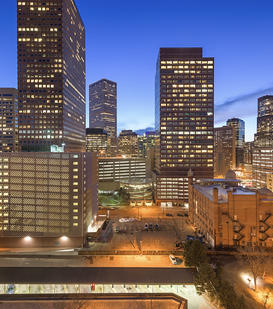 Denver skyline at dusk, city lights illuminate buildings