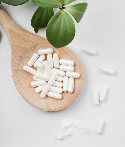 herbal-pills-in-wooden-spoon-and-green-plant-leave