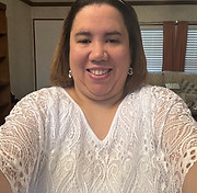 A woman with brown hair and a white shirt smiling