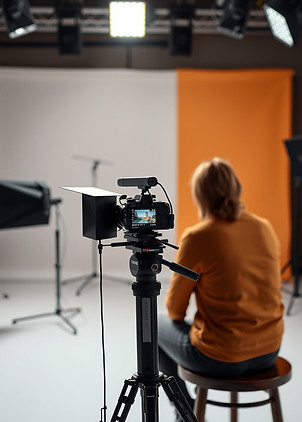 A person sat behind a camera in a studio