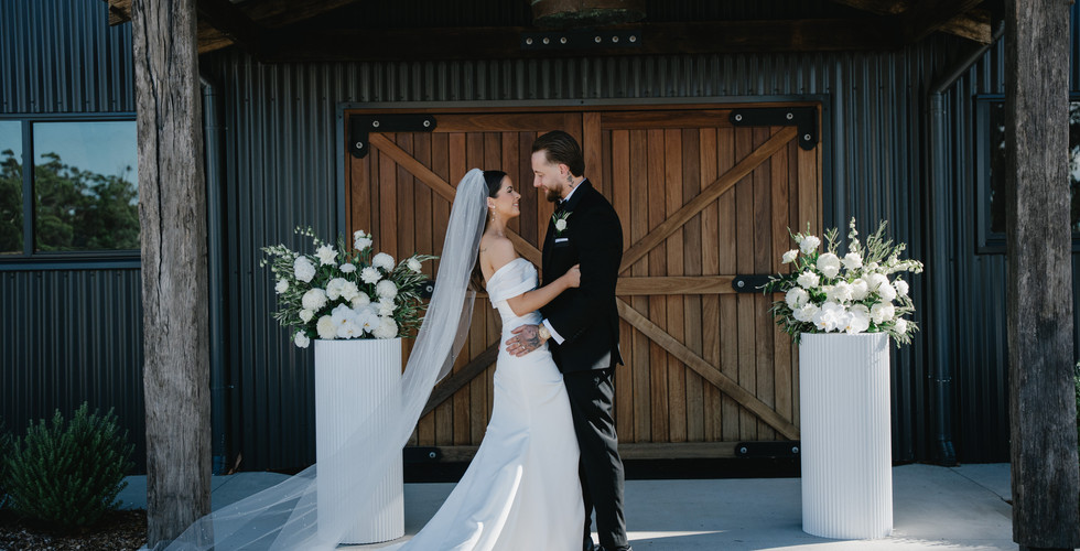 Outdoor wedding ceremony at Leonards Hill Estate Courtyard, a rustic Daylesford wedding venue near Melbourne with timber portico backdrop.