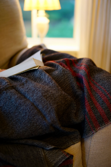 Thumbnail: Woman Reading in Armchair with Handwoven Luxury Wool Throw Blanket
