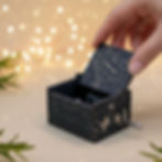 Open "Fix You" music box held in hand, revealing a hidden "I love you" heart-shaped puzzle engraving.