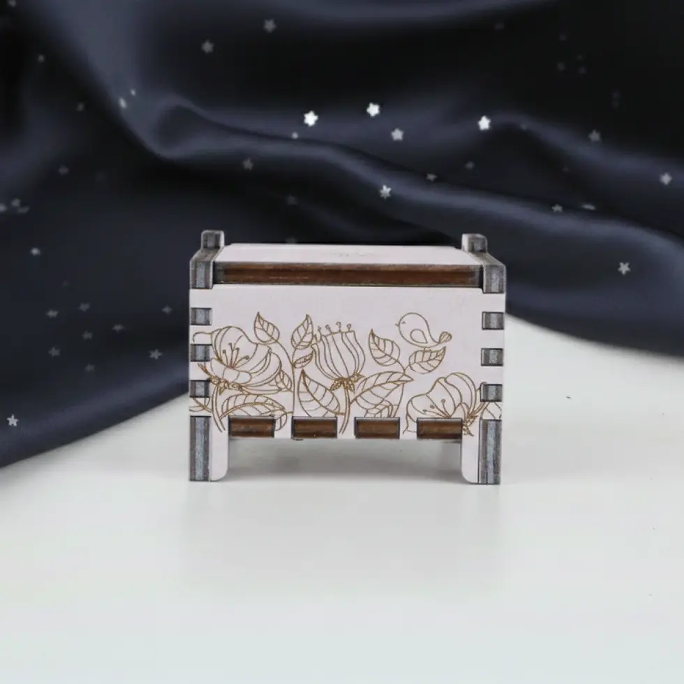 Miniatură: Front view of an off-white wooden music box with a intricate laser-engraved garden flowers.