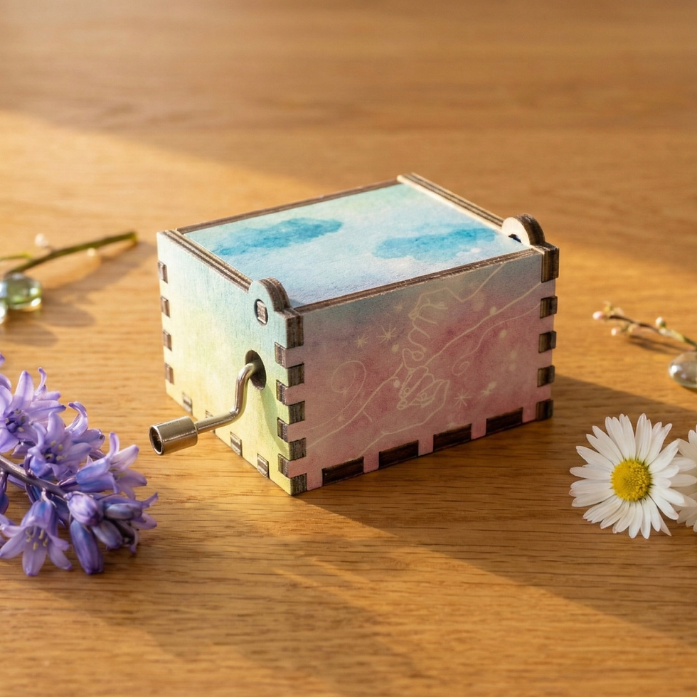 Miniatură: Back view of rainbow music box showing engravings on a pastel blue and pink rainbow wooden material.