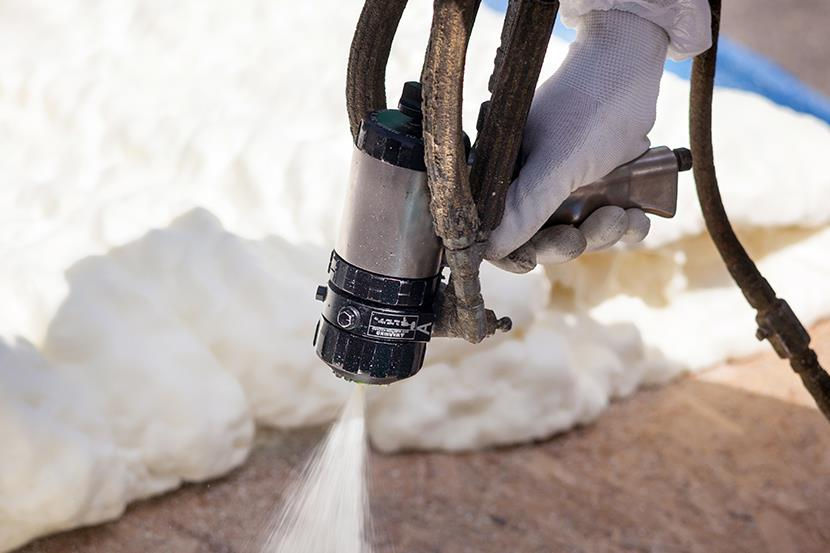 closeup of hand holding foam insulation sprayer spraying foam 1 4 5 1.jpg