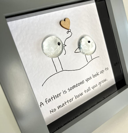 glass pebble people holding a balloon in a frame as a gift