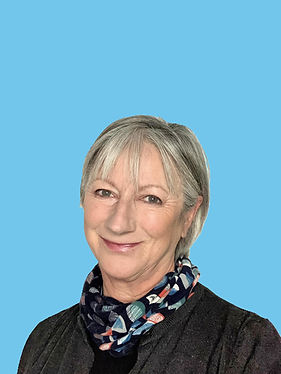 Gill Luff, smiling at camera with a coloured background.