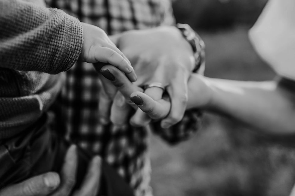 lack and white photo of a family holding hands