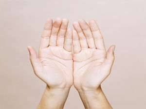 Two open hands facing up against a soft beige background, conveying a neutral or welcoming mood.