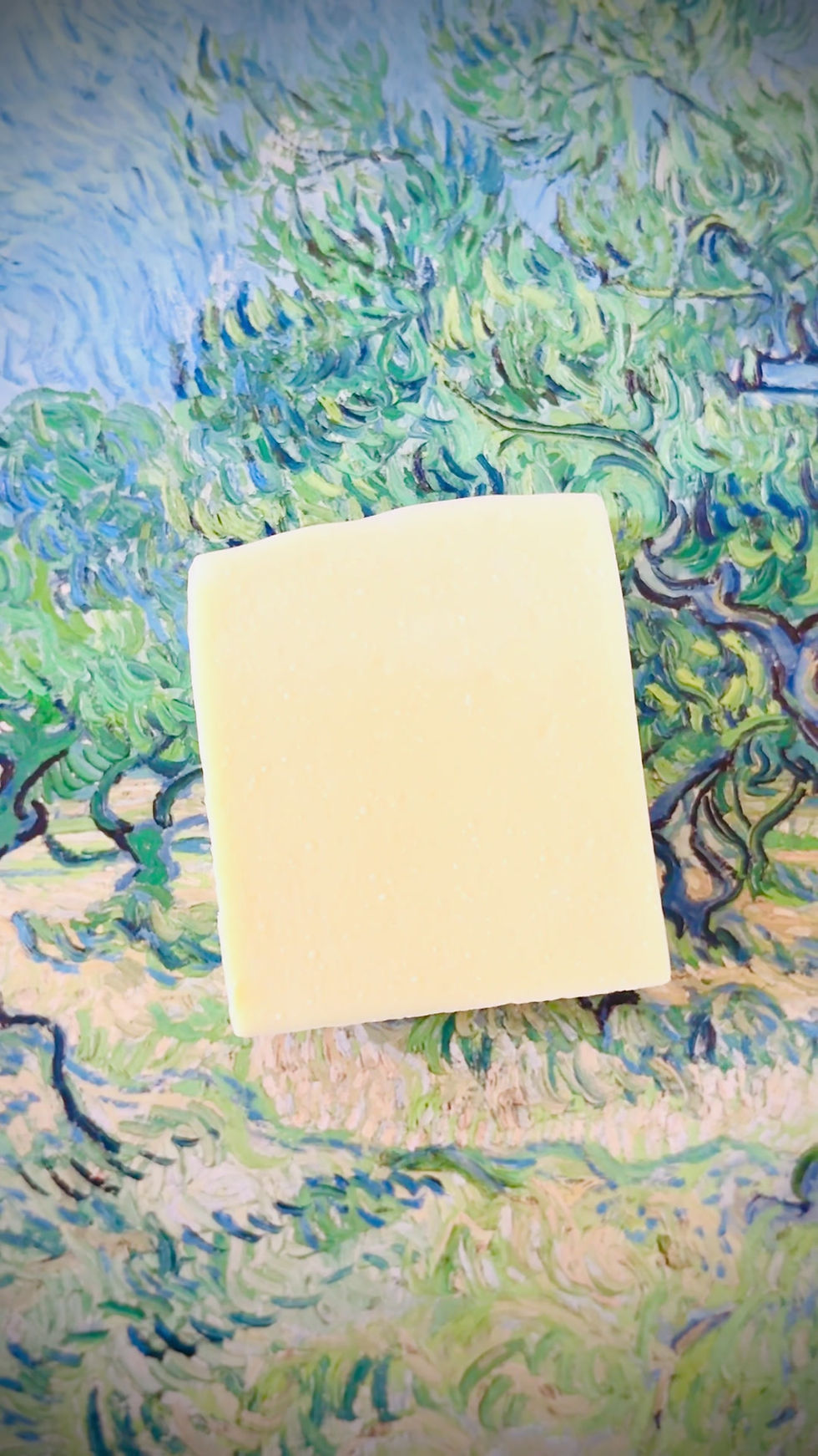 Thumbnail: Angled view of The Ylang Ylang Lime Castile Soap Bar without label, set against a dynamic, colorful artistic background