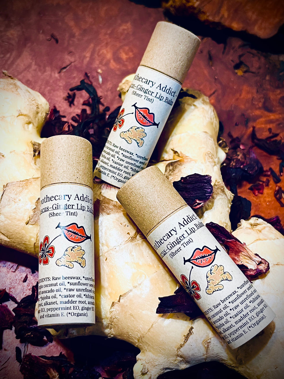 Thumbnail: Hibiscus Ginger Sheer Tinted Lip Balm displayed in three labeled eco-tubes with lids on