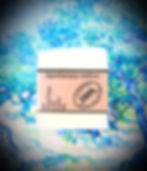 The Ylang Ylang Lime Castile Soap Bar with hand-drawn label displayed on a vibrant, artistic backdrop of layered color