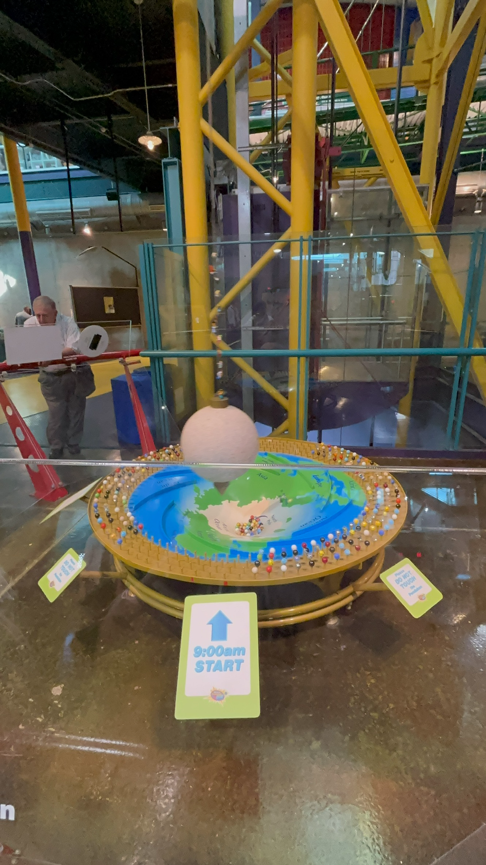 This Manual Clock Swings Back And Forth, Knocking Down A Marble As Time Goes On Per Swing