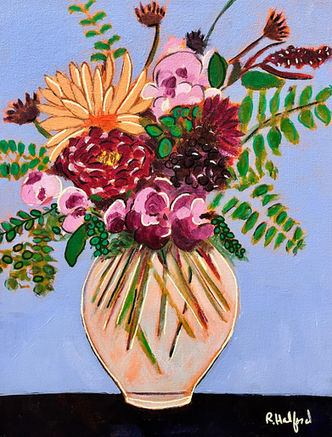 A vase of colorful flowers set on a table with blue background. 