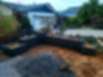 Dark concrete fire pits and planters in a yard