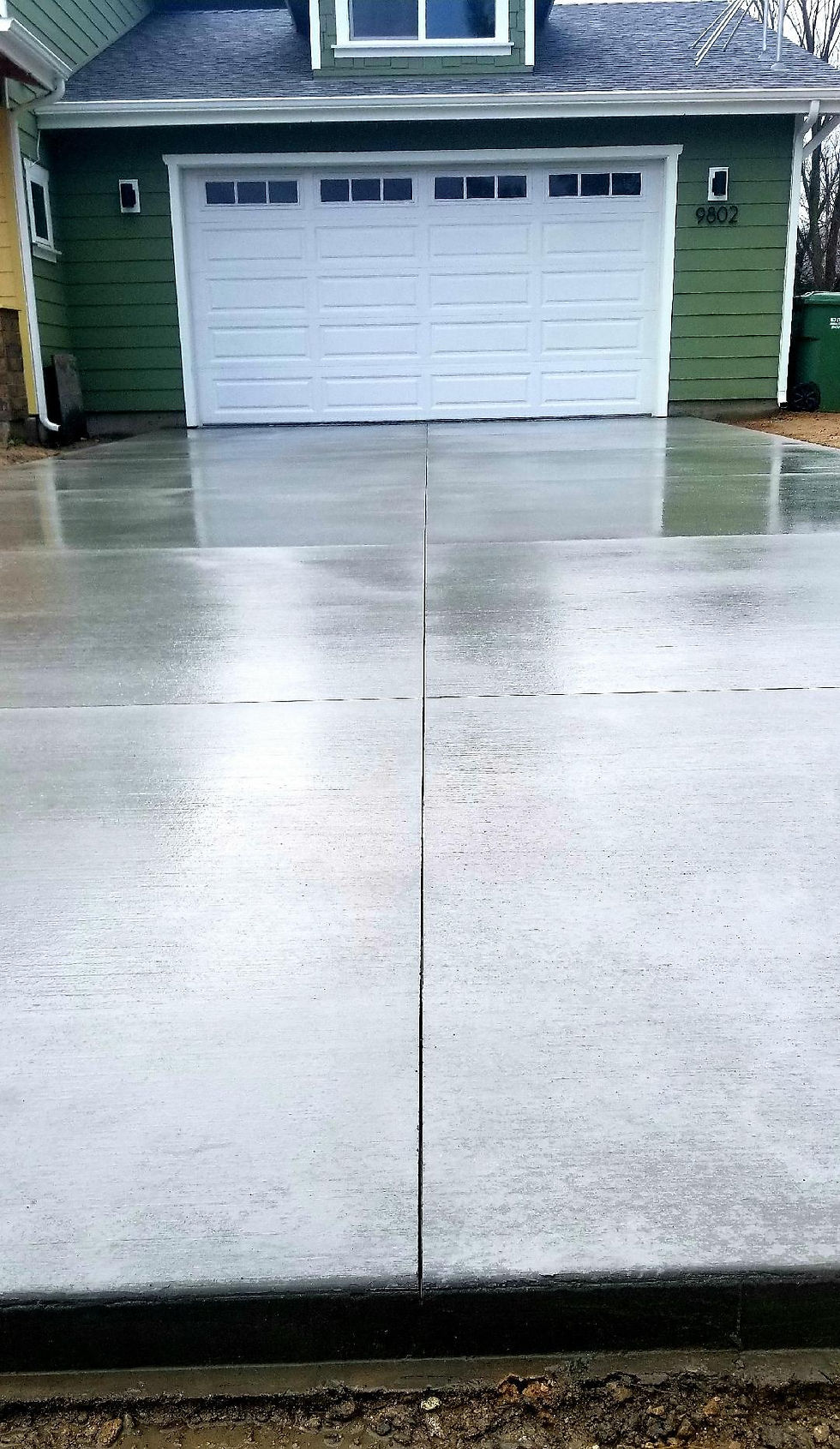 New concrete driveway leading to a house
