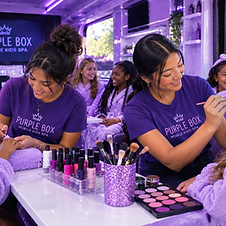 Purple Box Mobile party hosts doing glam makeup on the spa bus