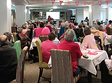 Woman stylist speaking to a group workshop — attendees learning colour and style confidence together.