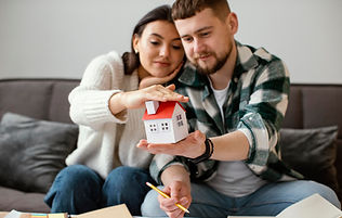 couple-holding-small-house-medium-shot.jpg
