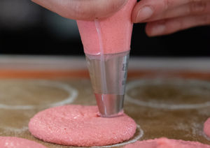 Macaron-Schalen werden von Hand aufgespritzt