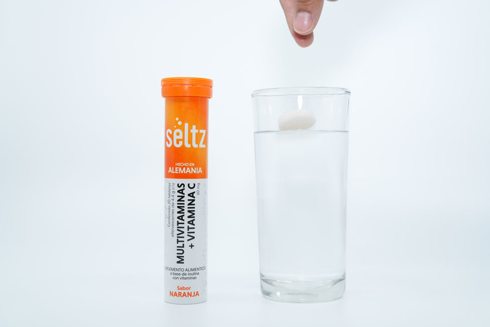 Pastilla efervescente Seltz cayendo en un vaso de agua
