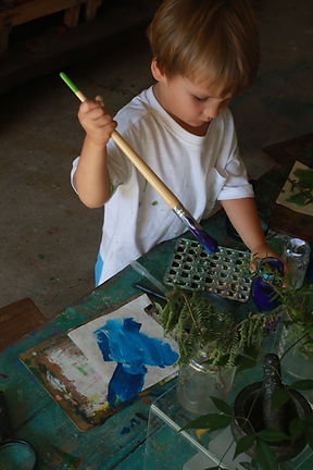 Child painting with natural materials at Bambini House early learning program