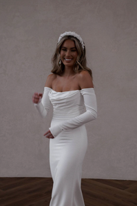 Bride wearing white crepe wedding dress with fitted long sleeves that are detachable