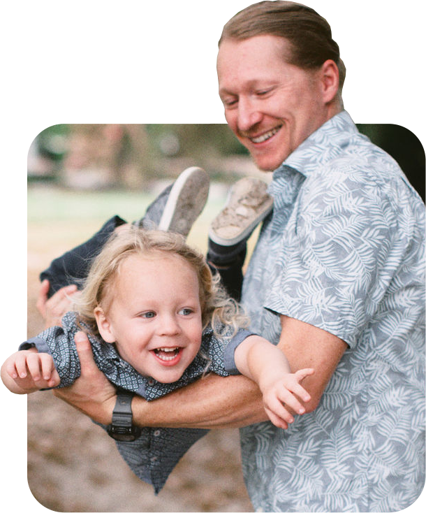 Dad holding son in a flying position.