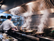 Steam and cooking fumes rising into a commercial kitchen exhaust hood in Utah.