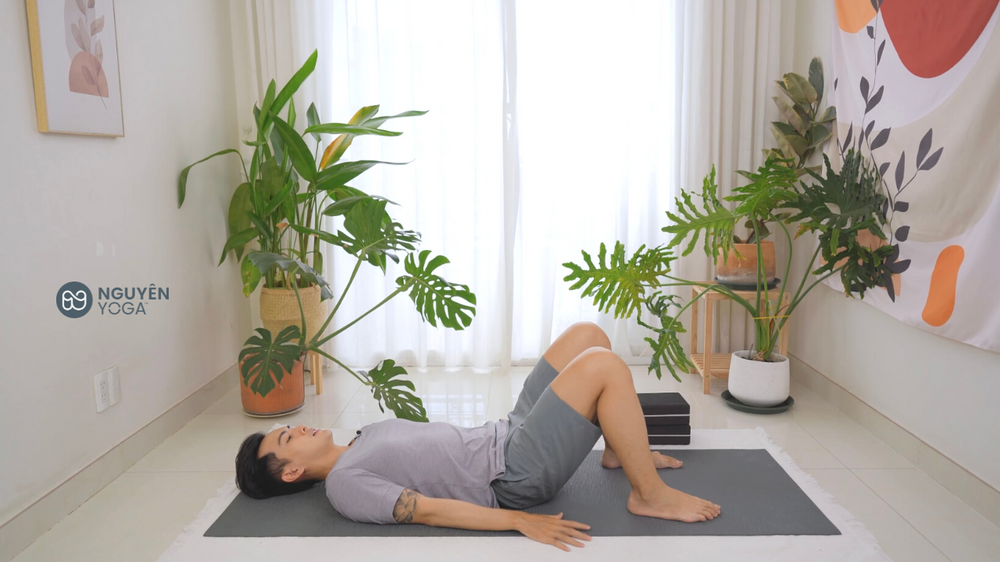 Nằm sát đất, hai tay xuôi hông, co đầu gối lại Tư thế Yoga cây cầu