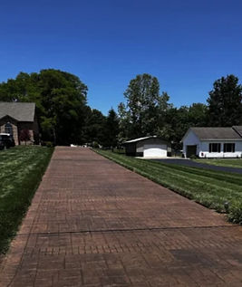 Long brown stamped concrete driveway in a brick pattern