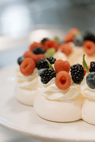 Exquisite cake display with fresh florals and fruit soft lighting, ideal for intimate luxury events.