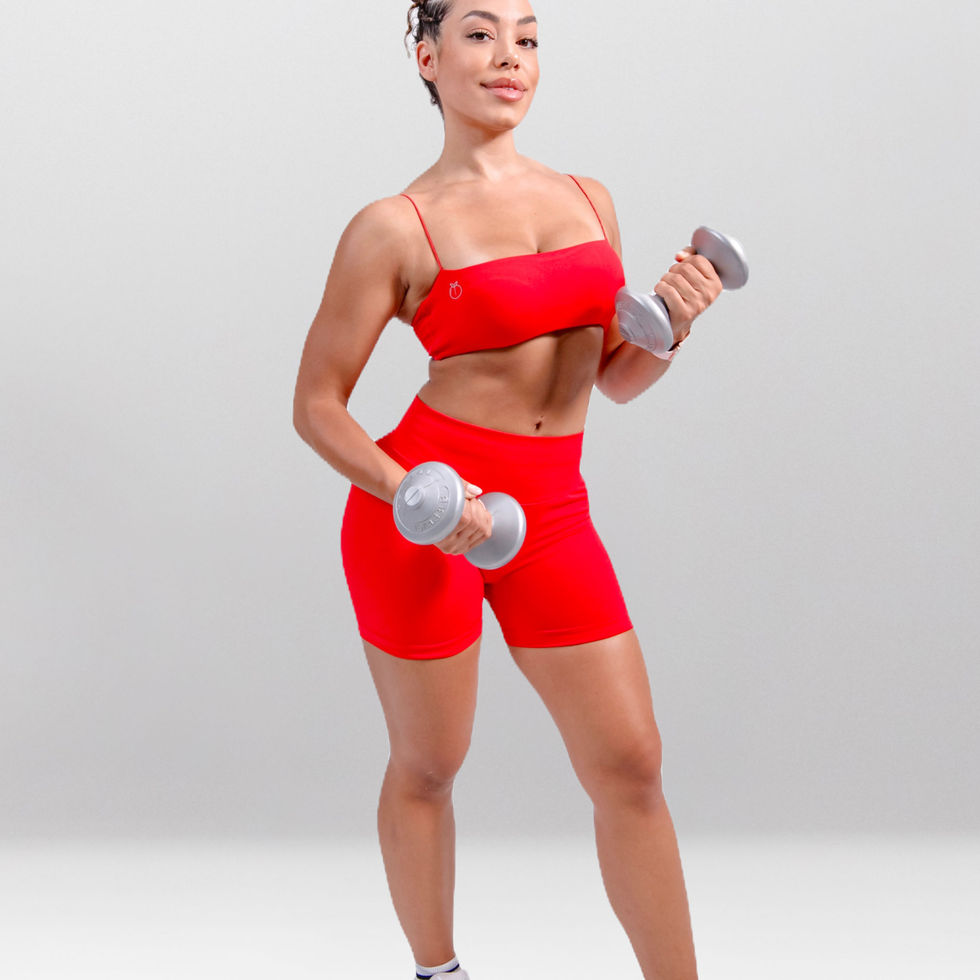 Kyveli Ember red gym set side pose – bold women’s sportswear with high-waisted shorts and strapless top