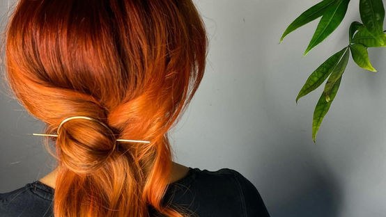 Koperkleurig haar in een zachte lage updo